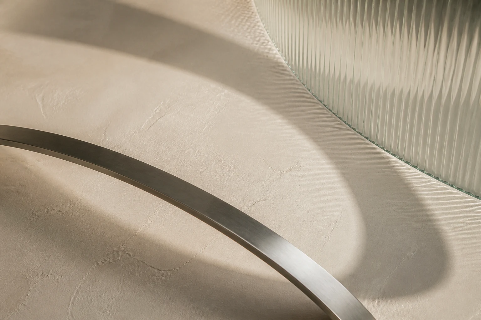 Frosted glass, curved shadow and brushed metal in an abstract precision study