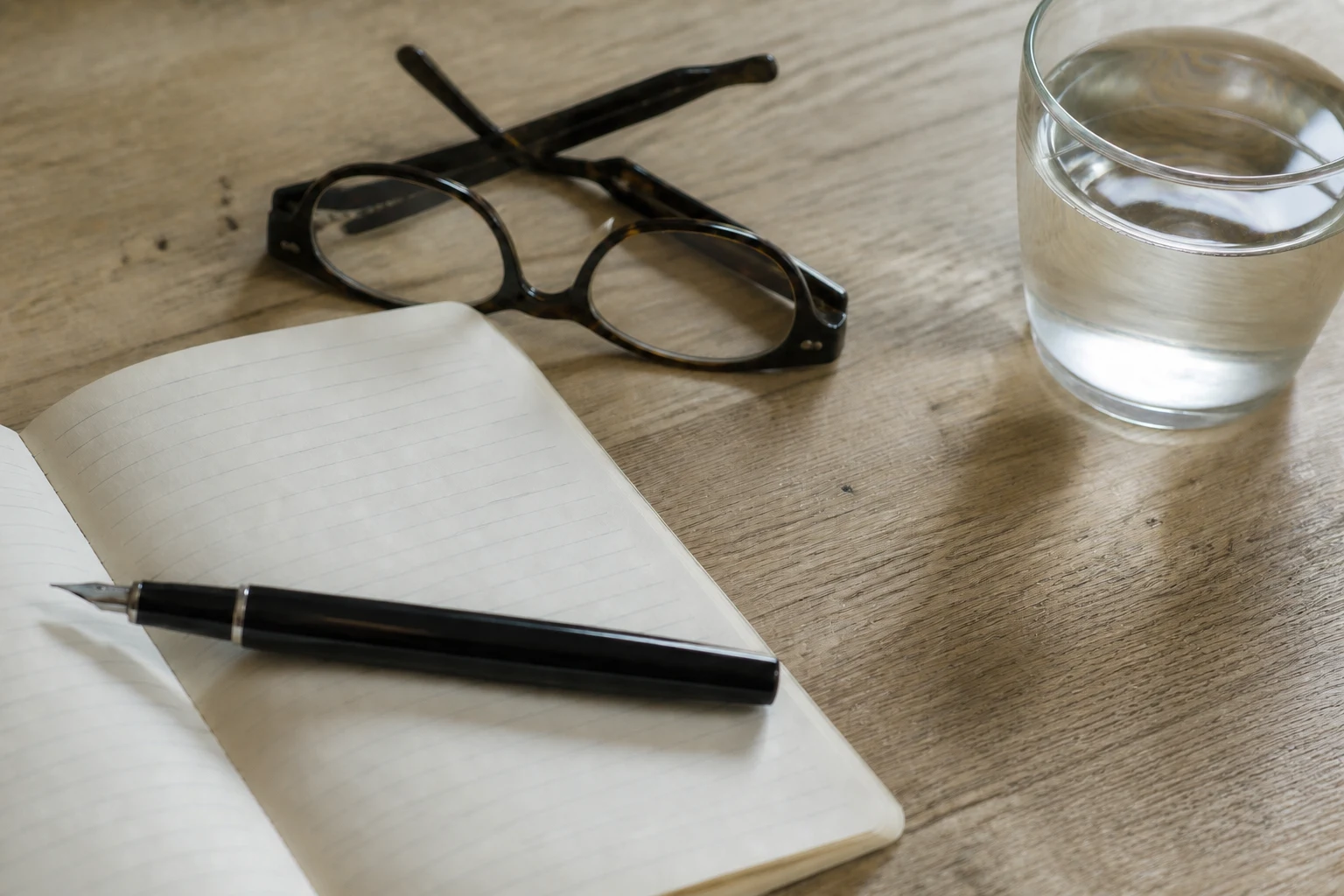 A notebook, reading glasses and water prepared for a private consultation